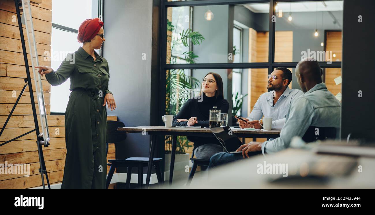Muslim team leader giving a presentation during an office meeting ...