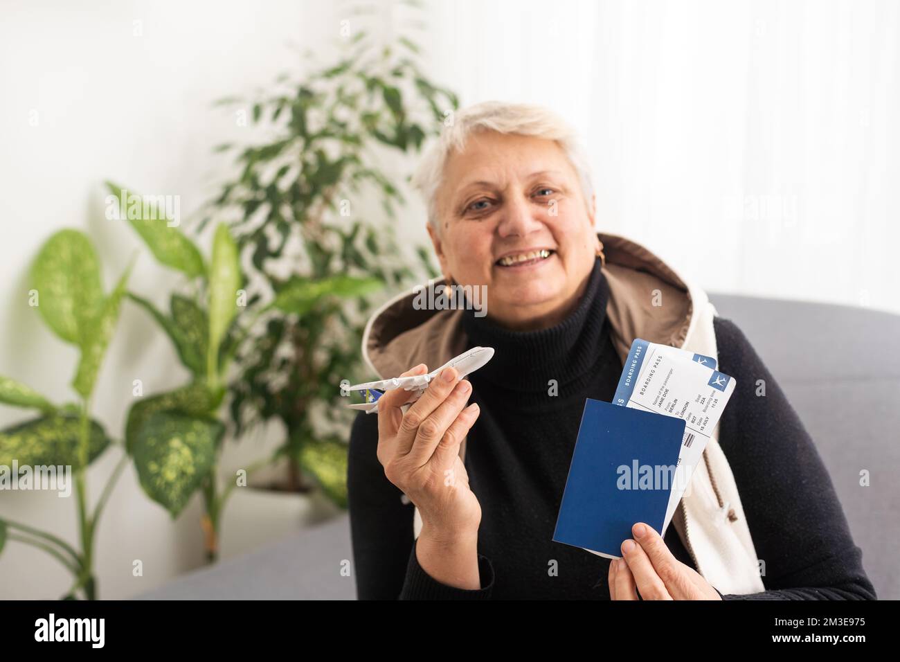 old woman with tickets and a toy airplane Stock Photo