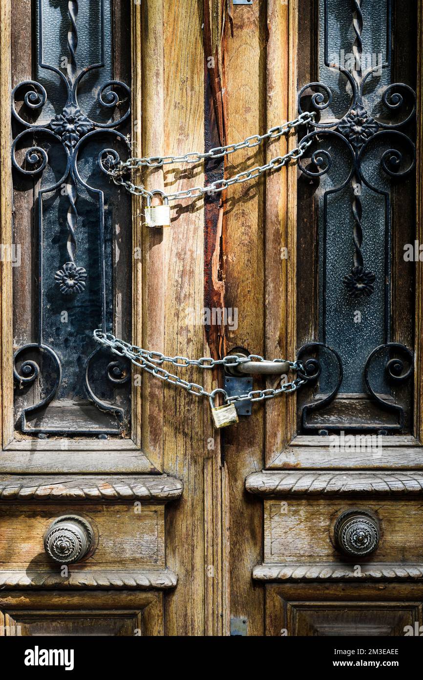 Old wooden door of an abandoned house is locked. Chain on the vintage door of a closed mansion. High quality photo Stock Photo