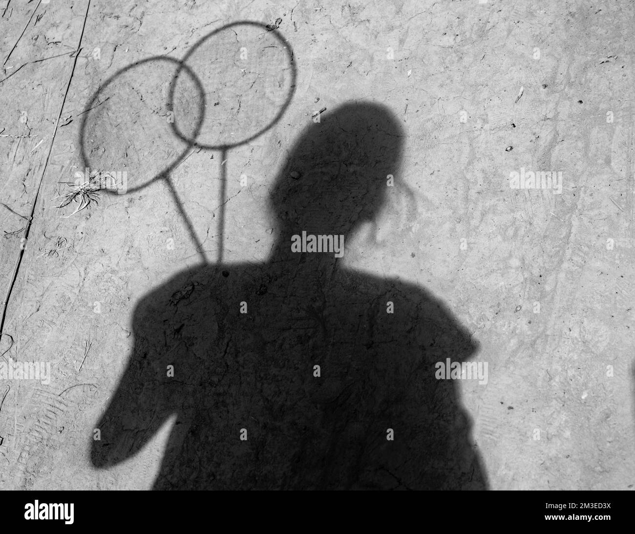 Shadow of a girl with rackets on the ground. A Ukrainian teenager with a lost childhood Stock Photo