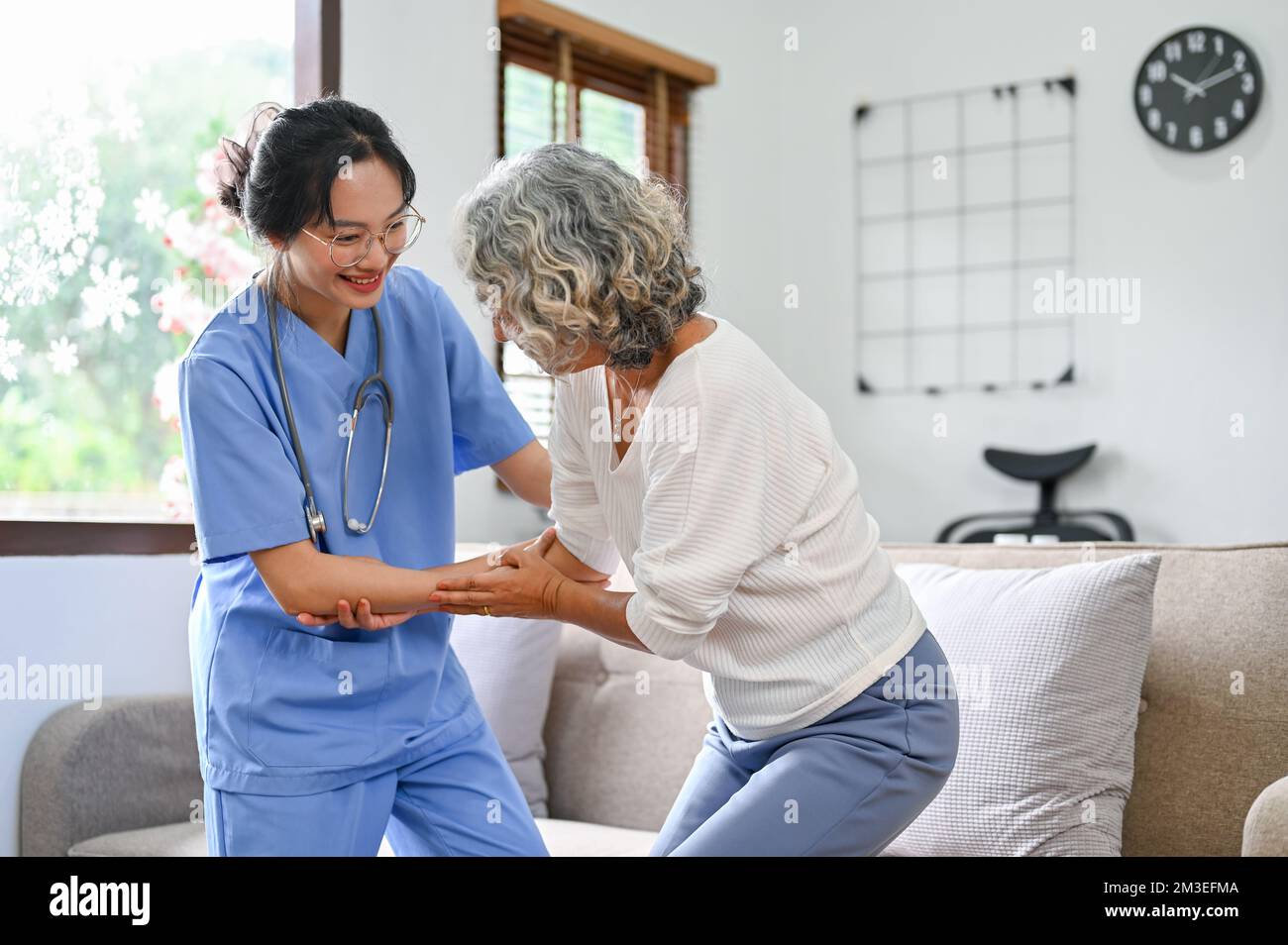 A 60yearold elderly retire woman being helped by a young female nurse