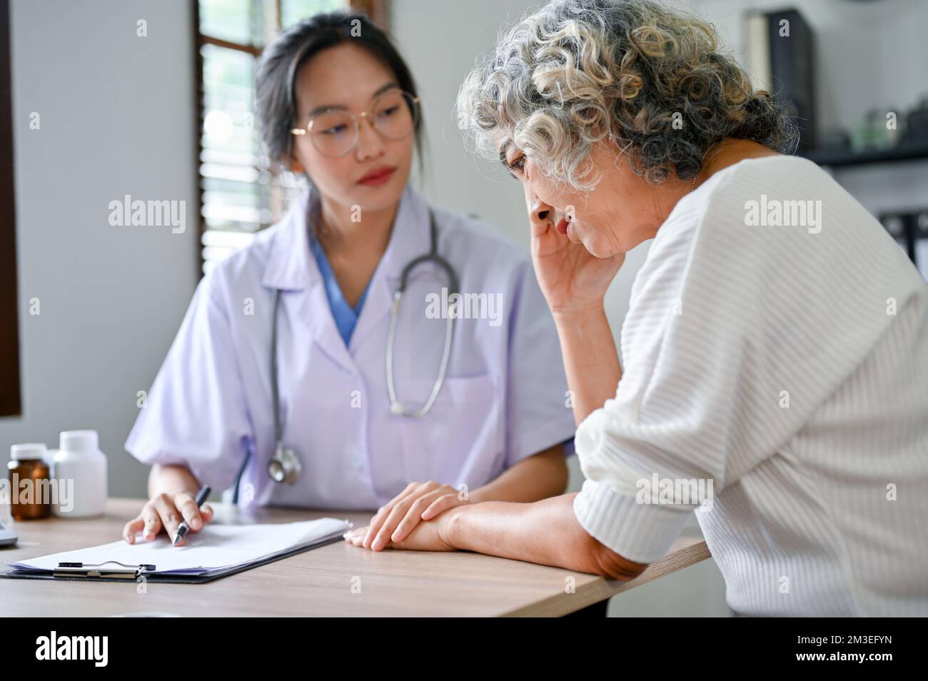 Serious and stressed 60yearold elderly retire woman talking, consulting with her doctor in the