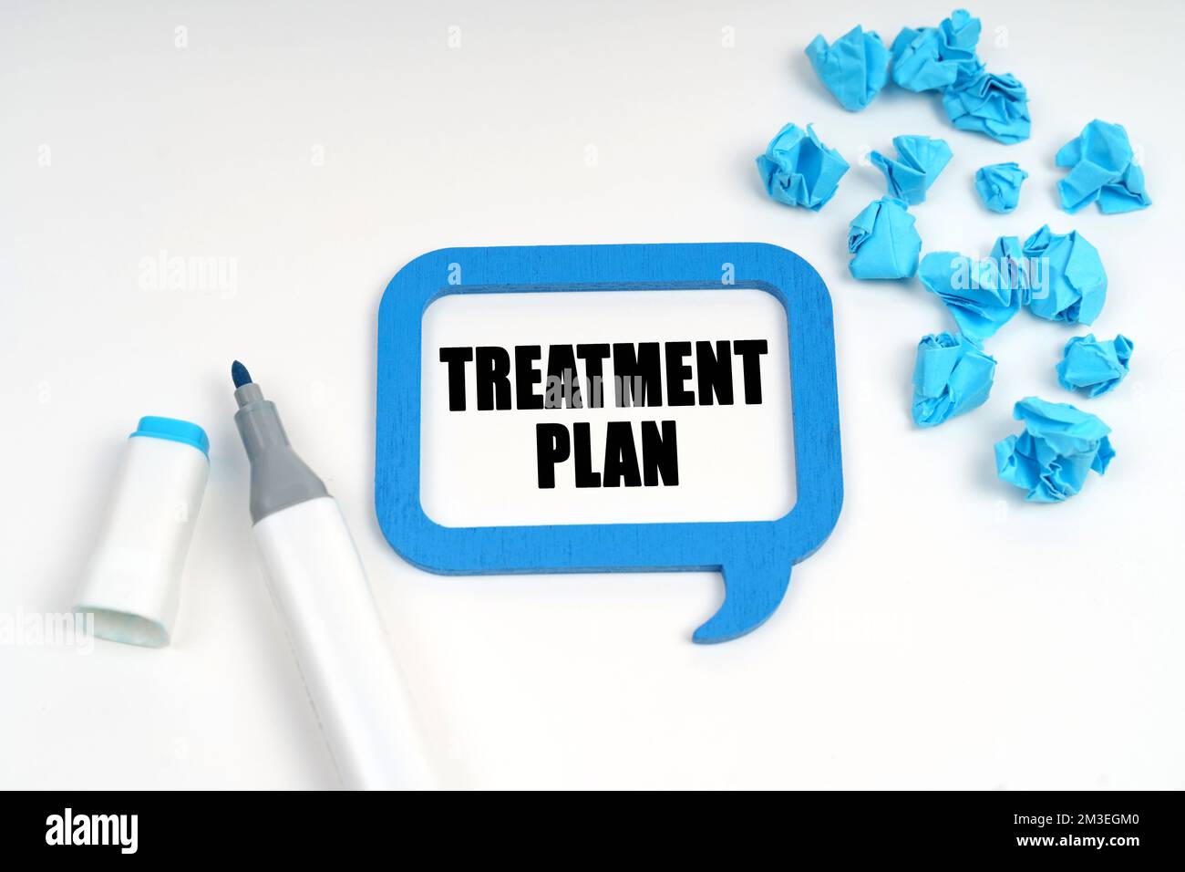 Medicine and health. On a white surface are crumpled blue paper, a marker and a sign inside which is written - TREATMENT PLAN Stock Photo