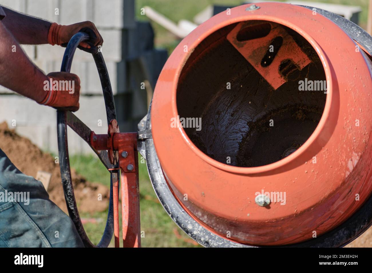 Bricklayer preparing concrete with a cement mixer to build a wall at a  construction site Stock Photo - Alamy, image size:1300x956