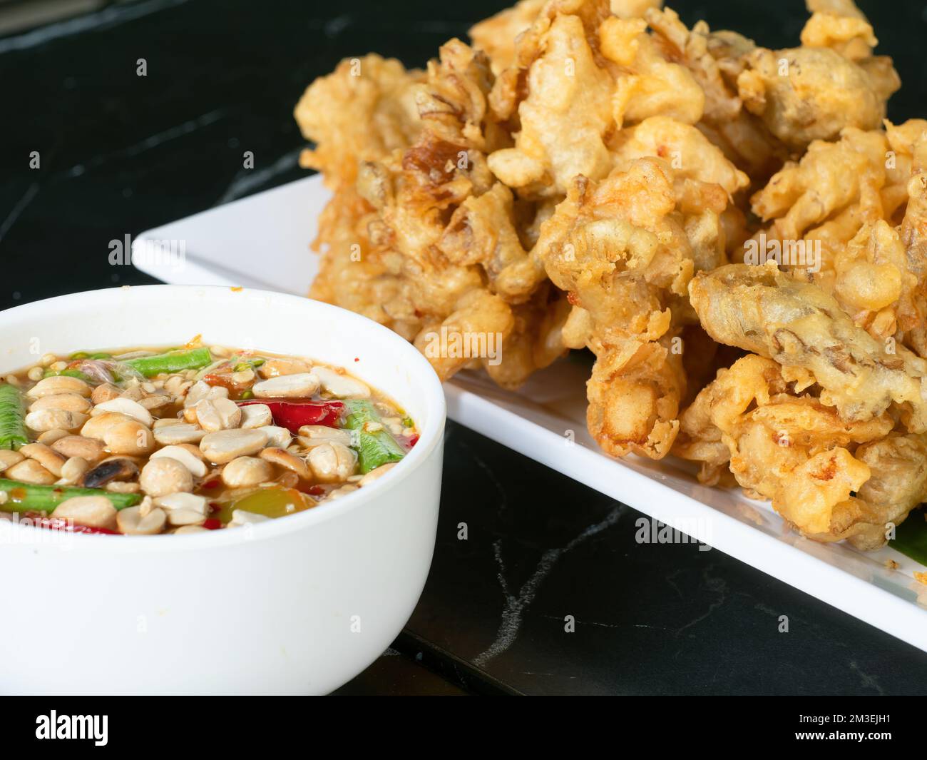 Japanese tempura style deep fried mushrooms with Thai som tam style hot sauce. The mild tempura