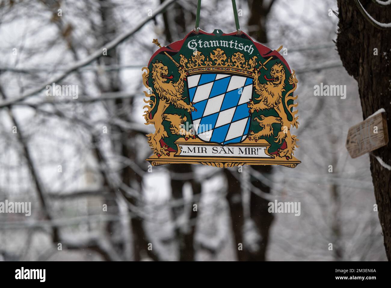 Munich, Germany. 15th Dec, 2022. A metal sign with the inscription 'Stammtisch - 'Mir sag Mir!' hangs in a snowy beer garden in the Haidhausen district. Credit: Peter Kneffel/dpa/Alamy Live News Stock Photo
