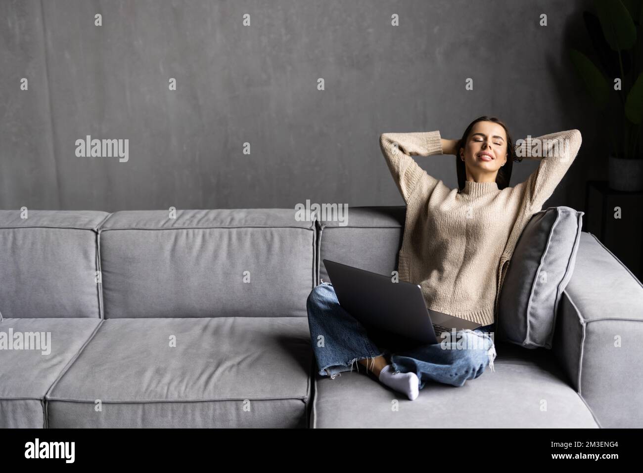 Happy pretty woman using laptop sitting on cosy sofa Stock Photo - Alamy
