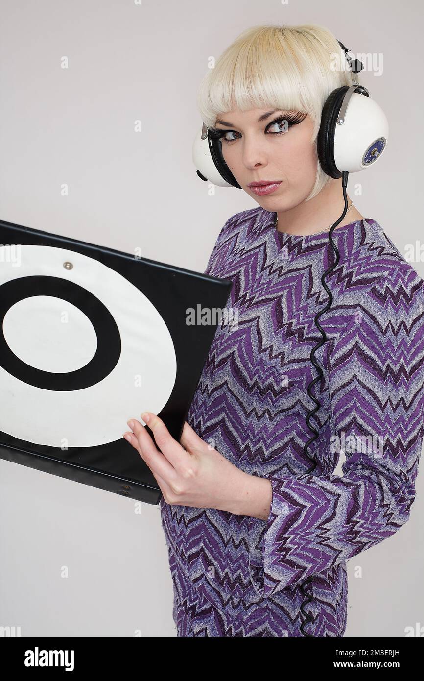 Woman holding record and listening to music on her headphones.Vintage portrait Stock Photo