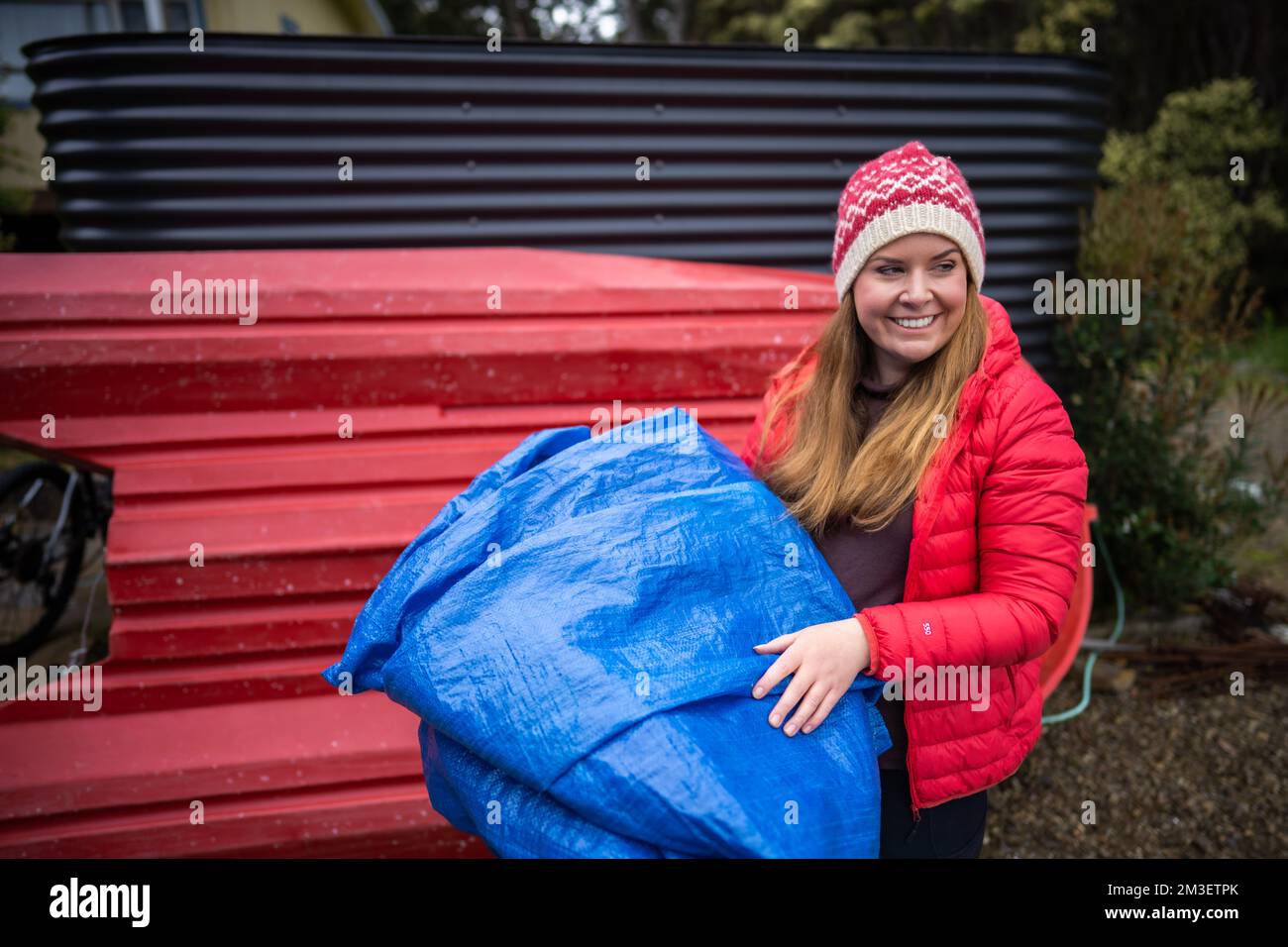 girl folding up a tent and blue tarp hiking Stock Photo Alamy