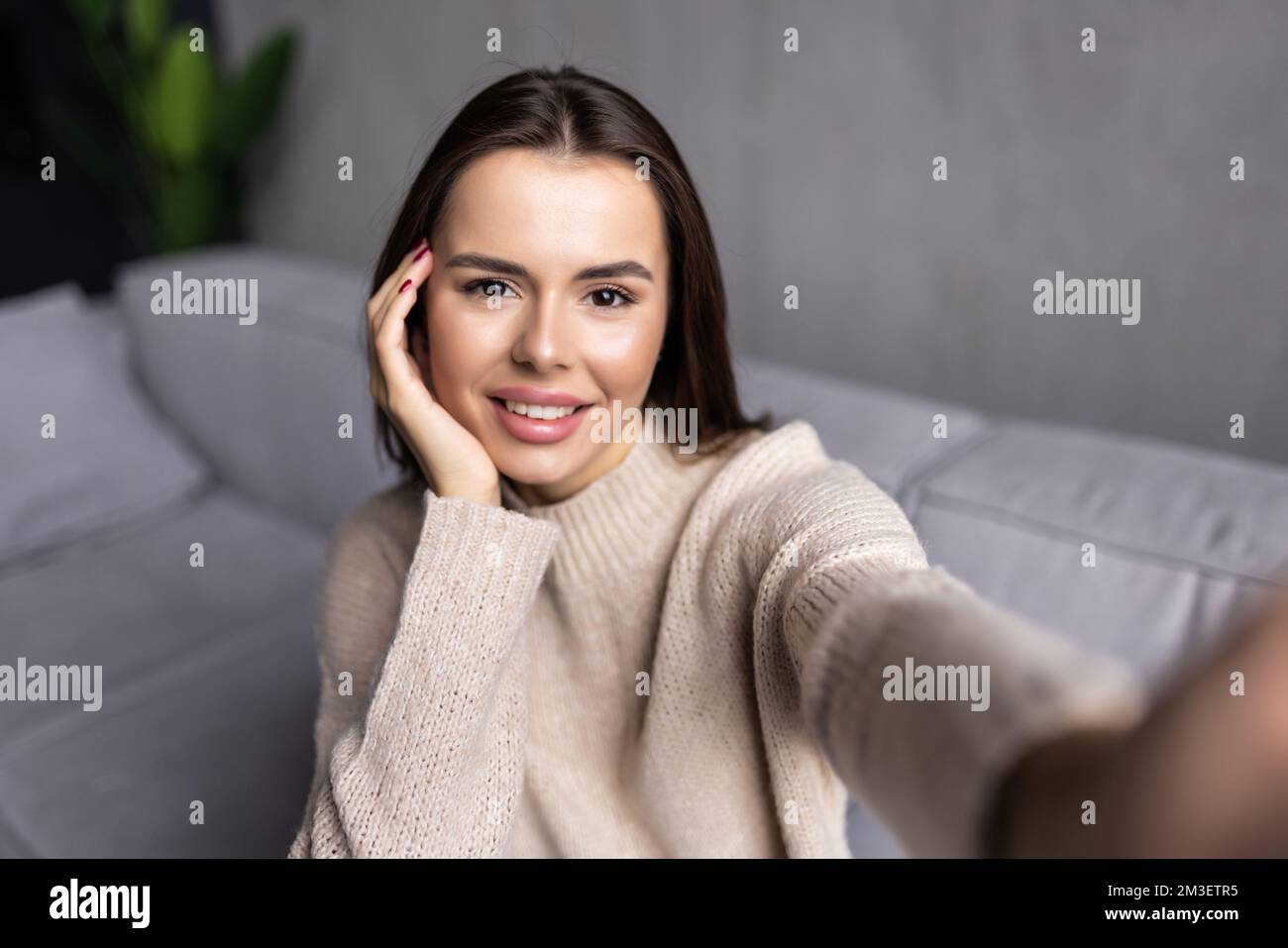 Cheerful beautiful girl smiling and taking selfie while resting on ...