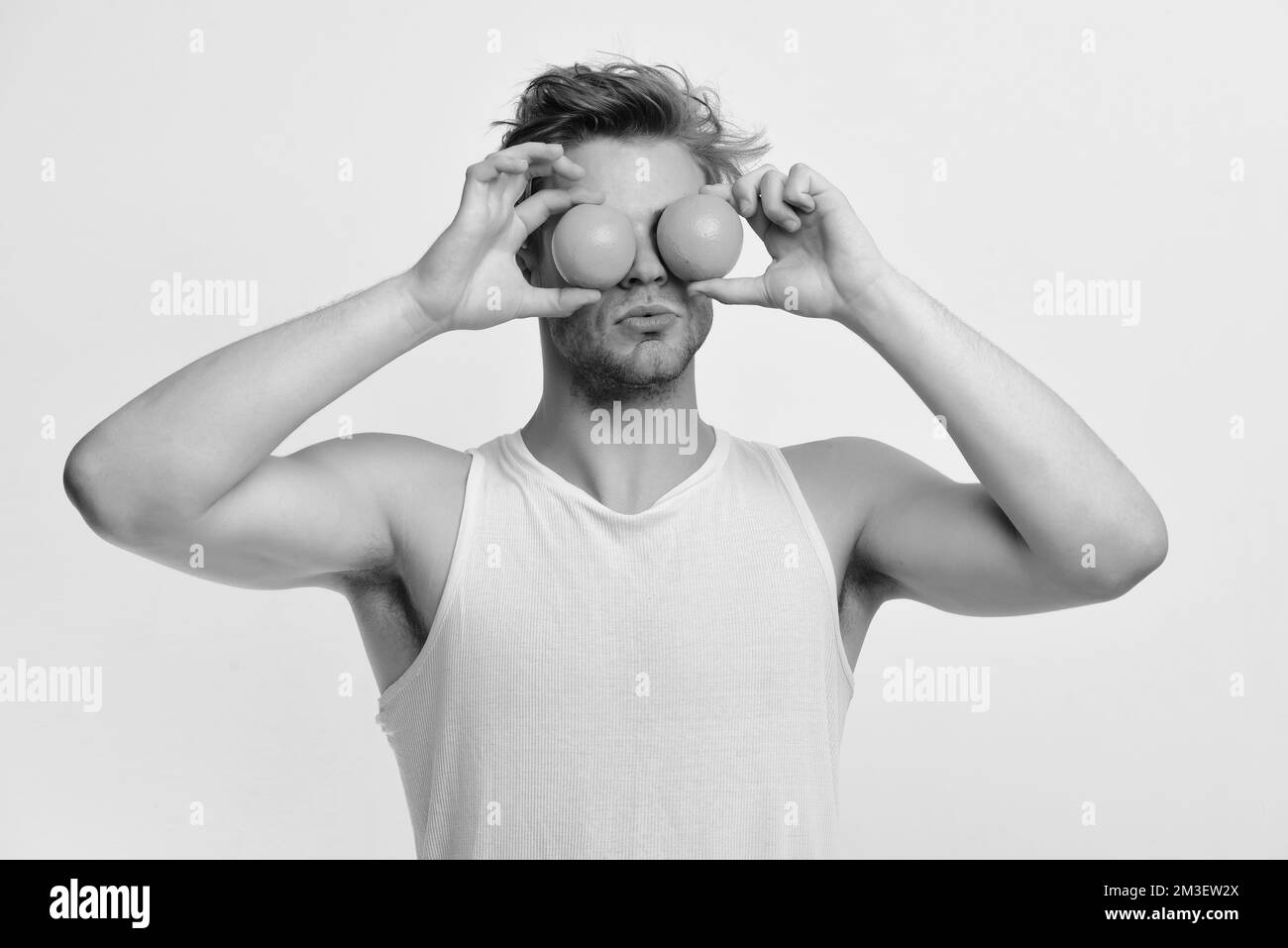 Athlete with messy hair holds fruit. Guy with serious face Stock Photo