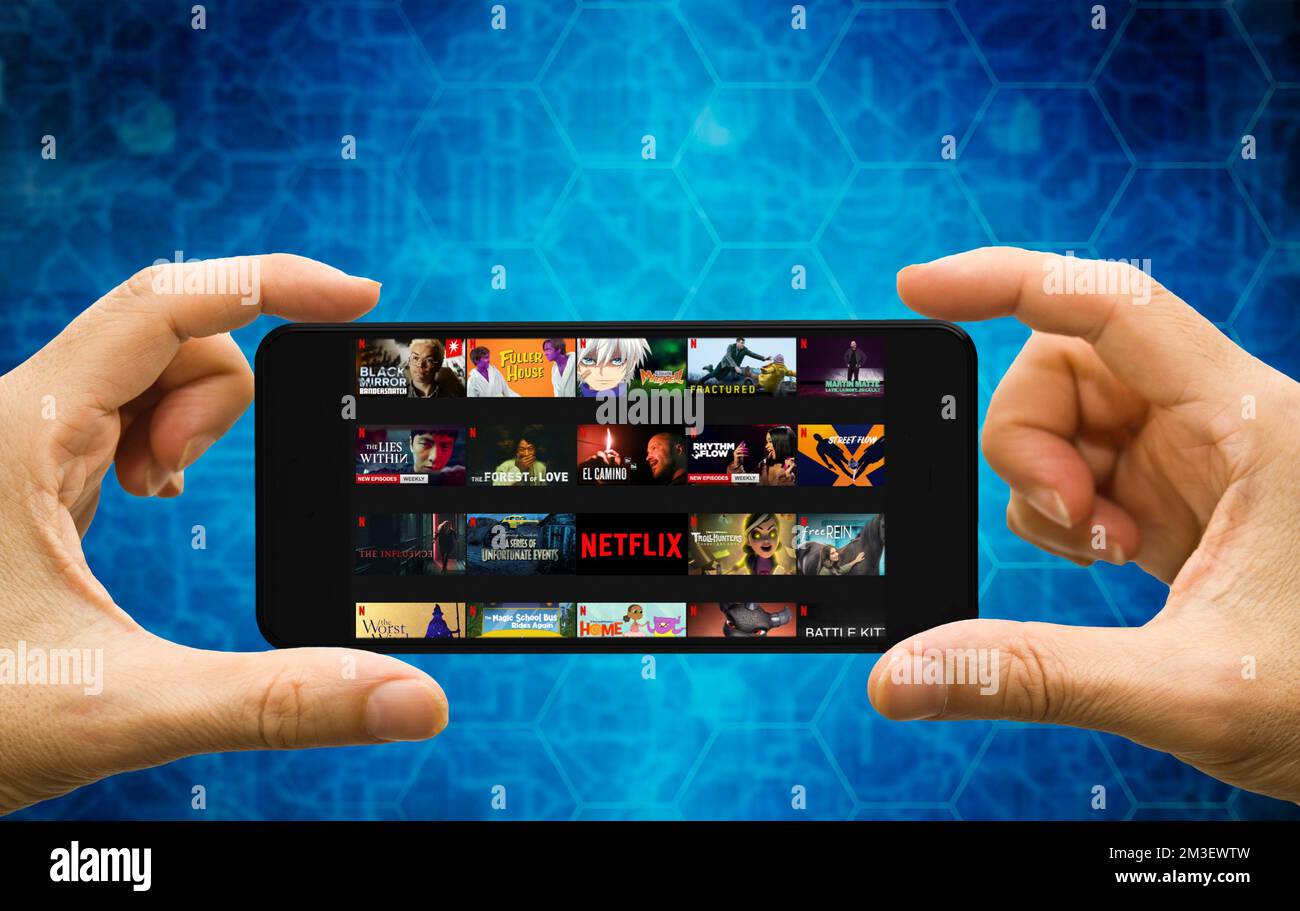 hands holding a smartphone with Netflix programs on the screen Stock Photo