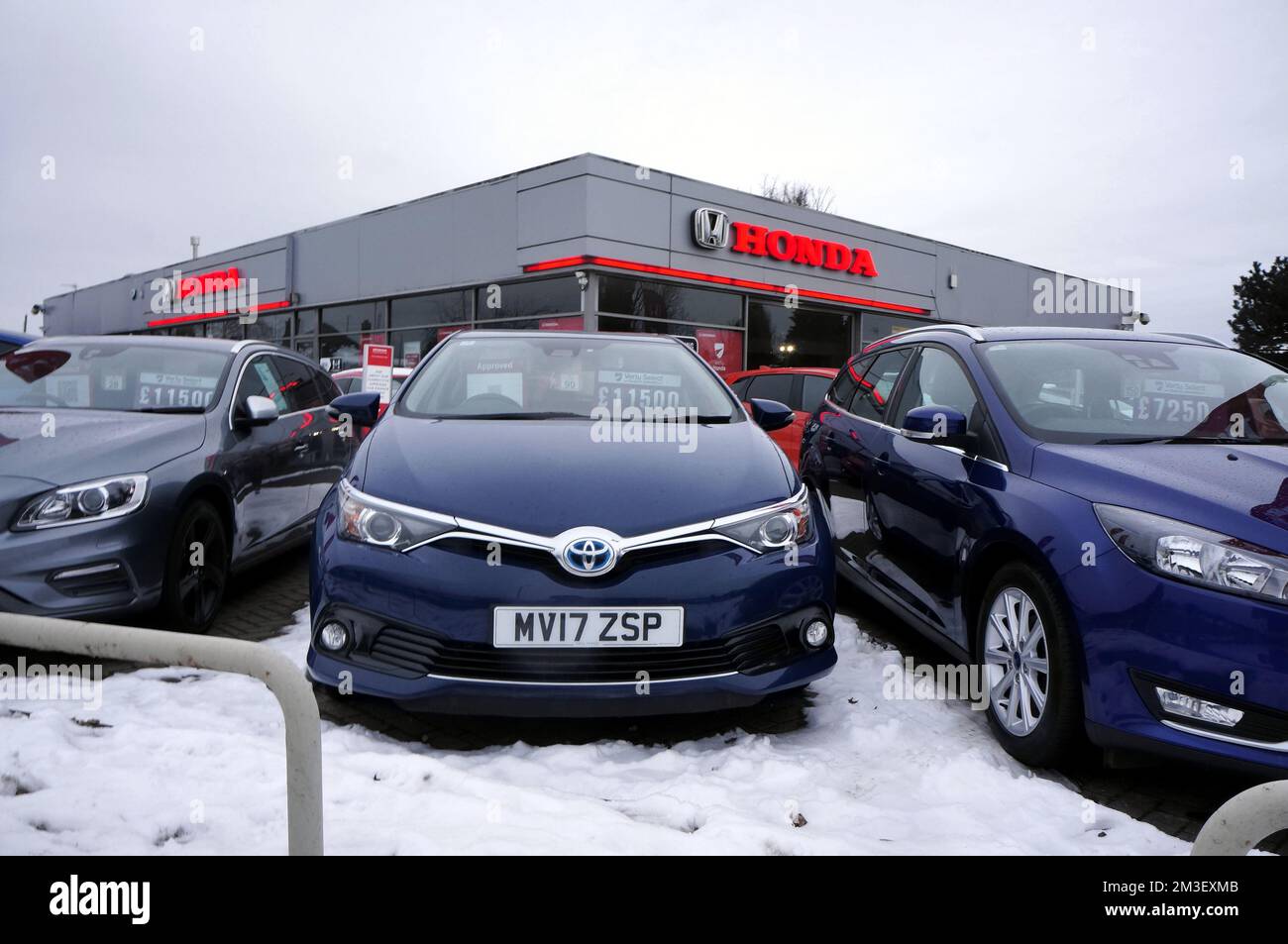 Cars for sale outdoors in the snow at a Honda sales dealership. Stock Photo