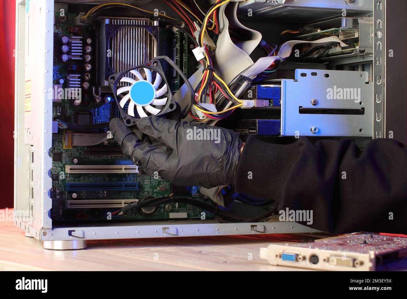 disassembly of the cpu cooling fan in the computer on a pink background