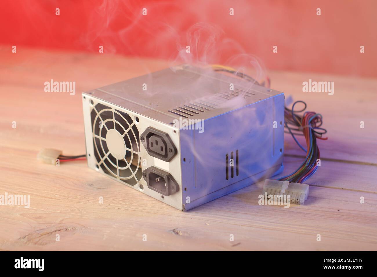 old computer power supply burning on the table and pink background Stock Photo Alamy