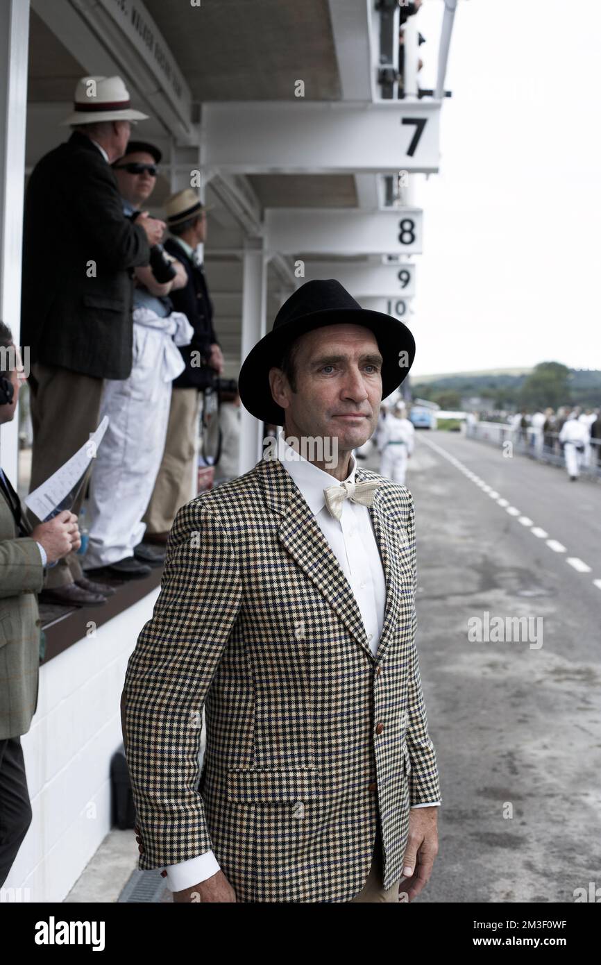 Enthusiasts enjoy dressing in period clothes to take part in and to enjoy the atmosphere of the Goodwood Revival which is held in Sussex, England. Stock Photo