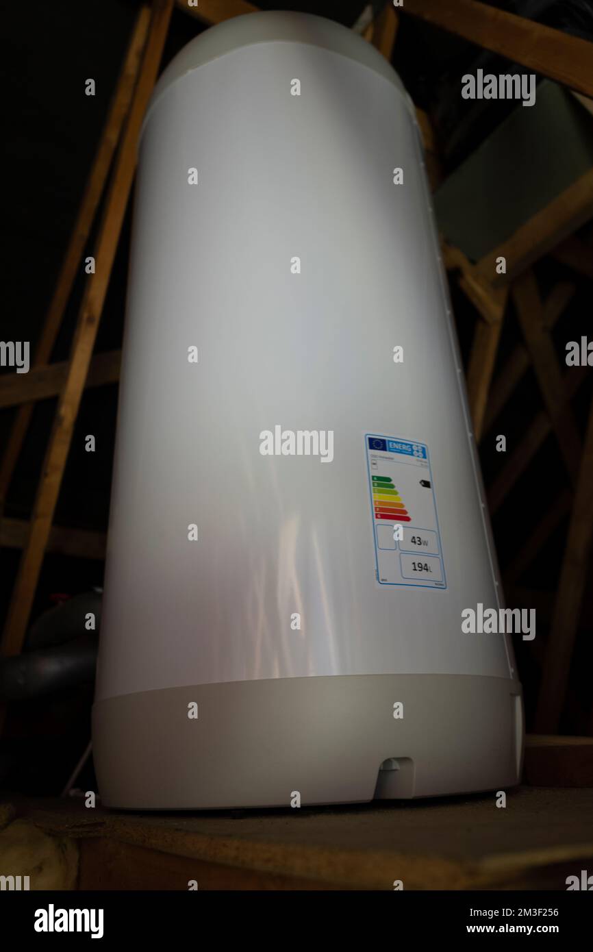 Fitting class A energy efficent hot water tank in loft of 1990's house. Stock Photo