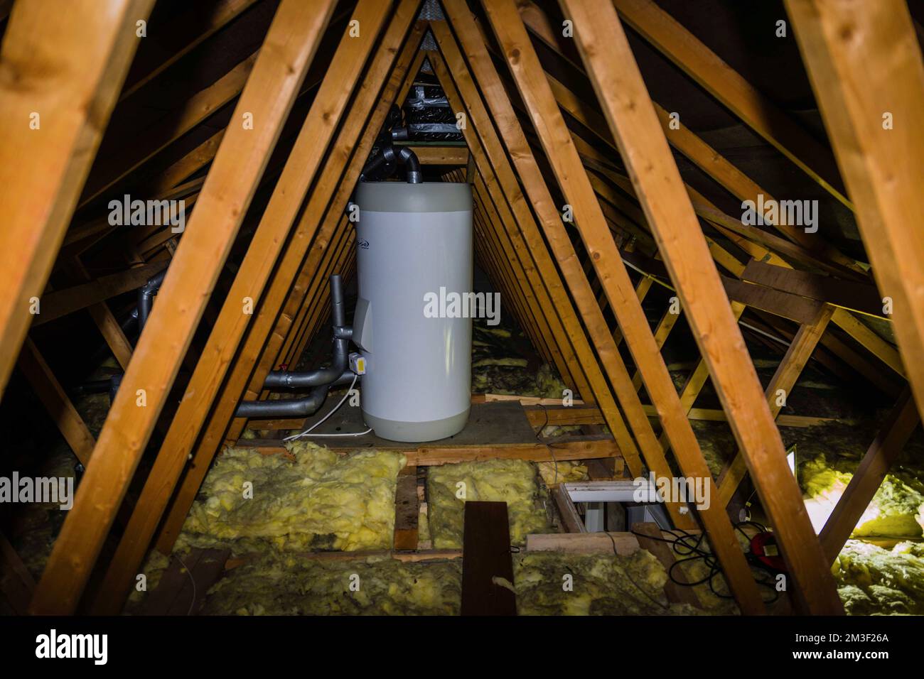 Fitting class A energy efficent hot water tank in loft of 1990's house. Stock Photo