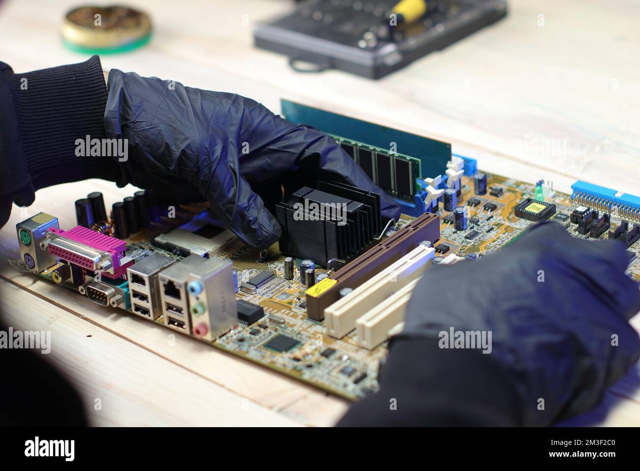 replacement of the chipset cooling system from the computer motherboard on the table Stock Photo