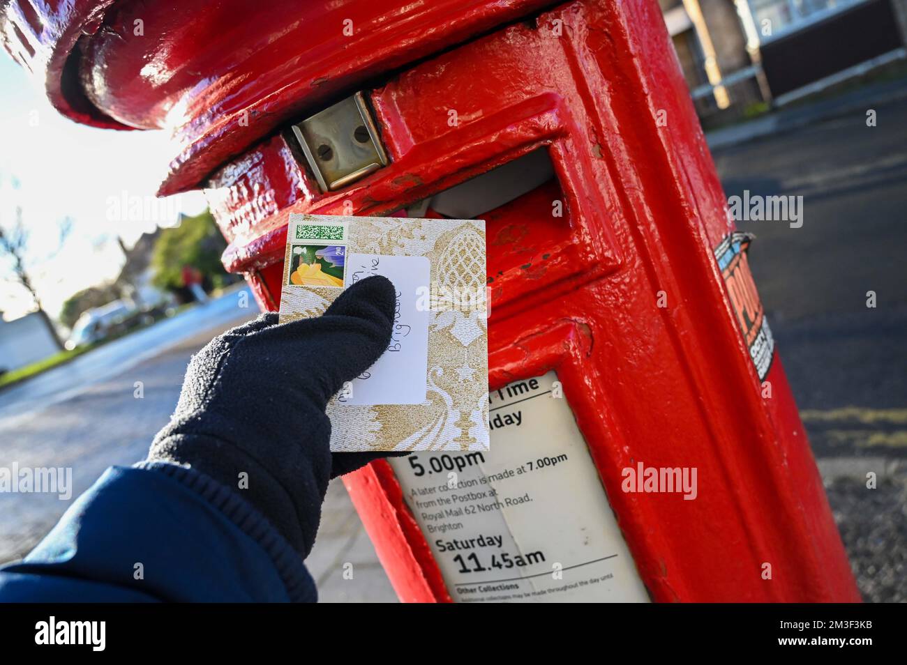 Christmas cards being posted from a red post box in Brighton during the