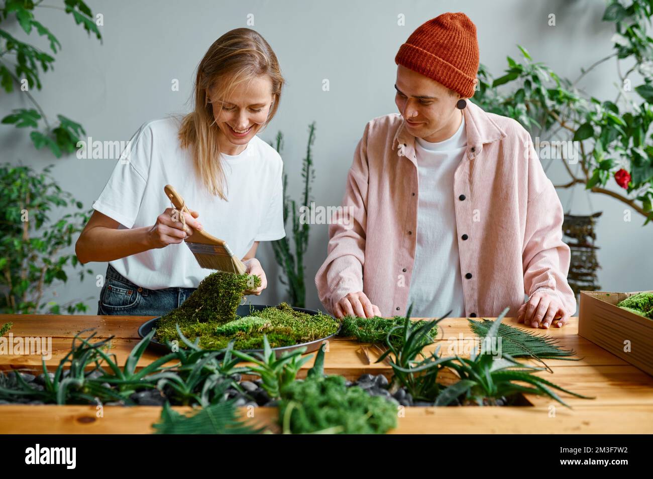 Young man and woman florist working at creative workshop Stock Photo