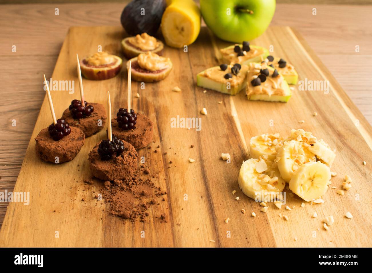 Presentation of fruits with peanut butter on a wooden board, healthy