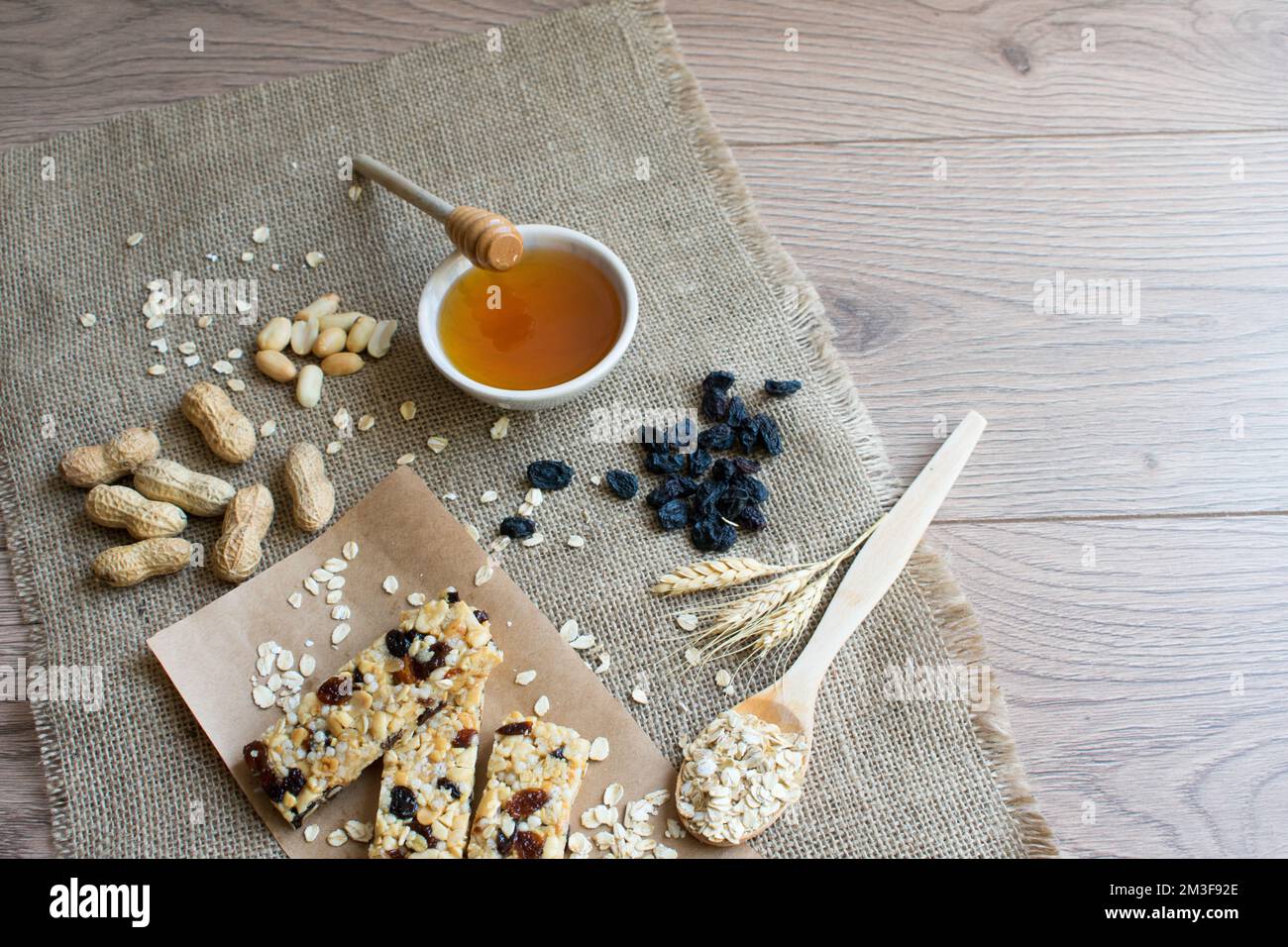 Granola bars, peanuts, oats, honey, grapes, healthy nutrition vegetarian snack, top view. Stock Photo