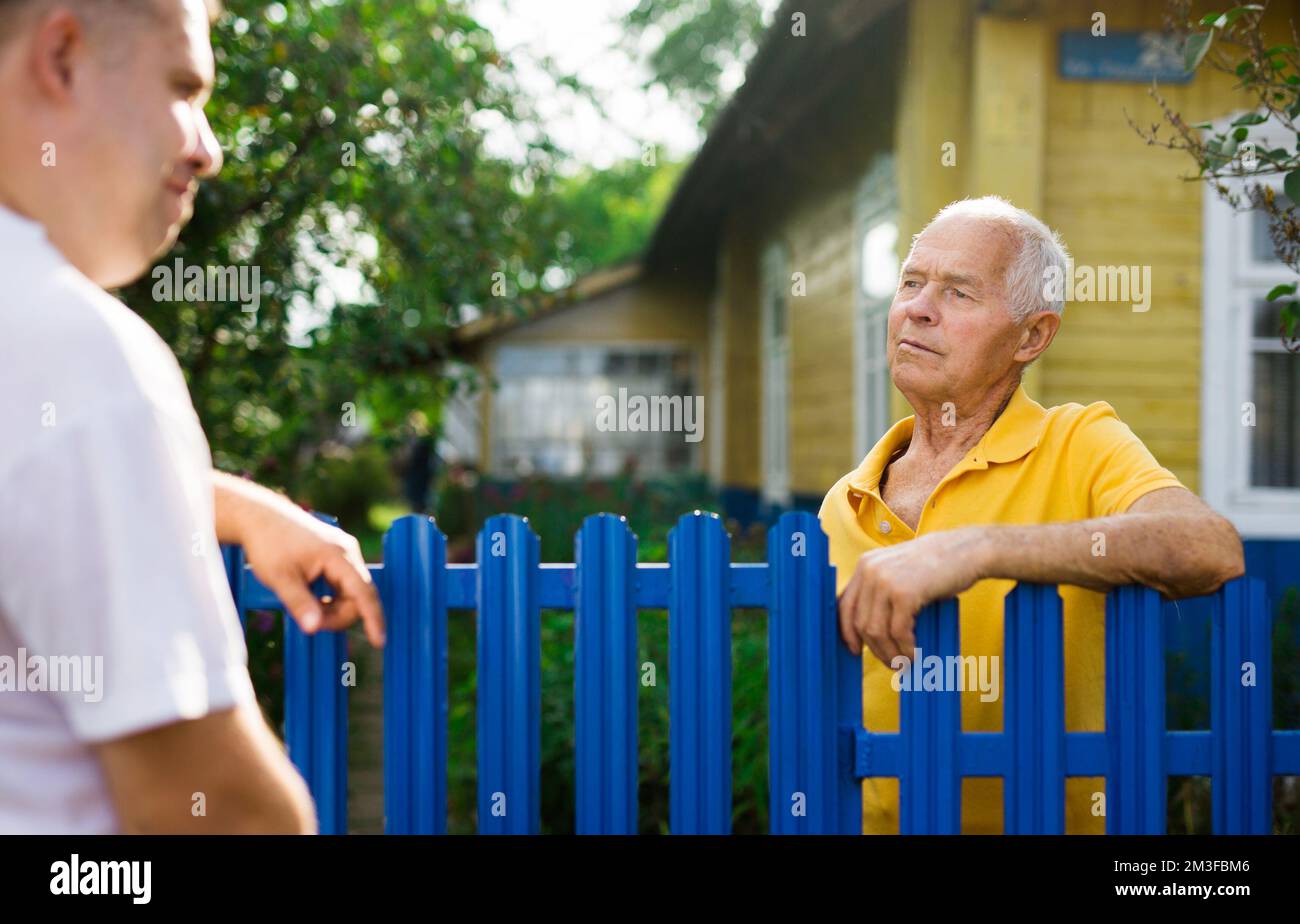 Old man talking with his neighbour Stock Photo