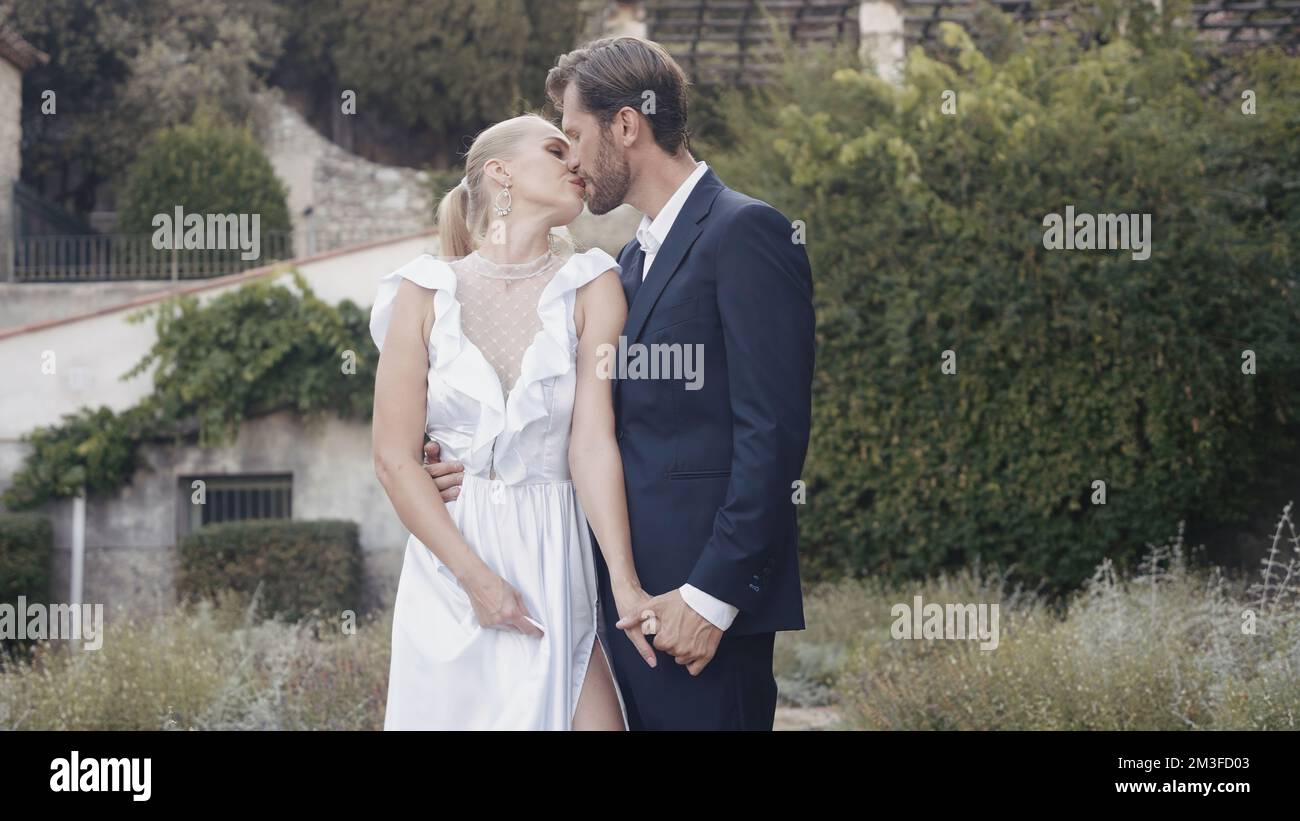 Newlyweds kiss and pose for camera. Action. Beautiful photo shoot of ...