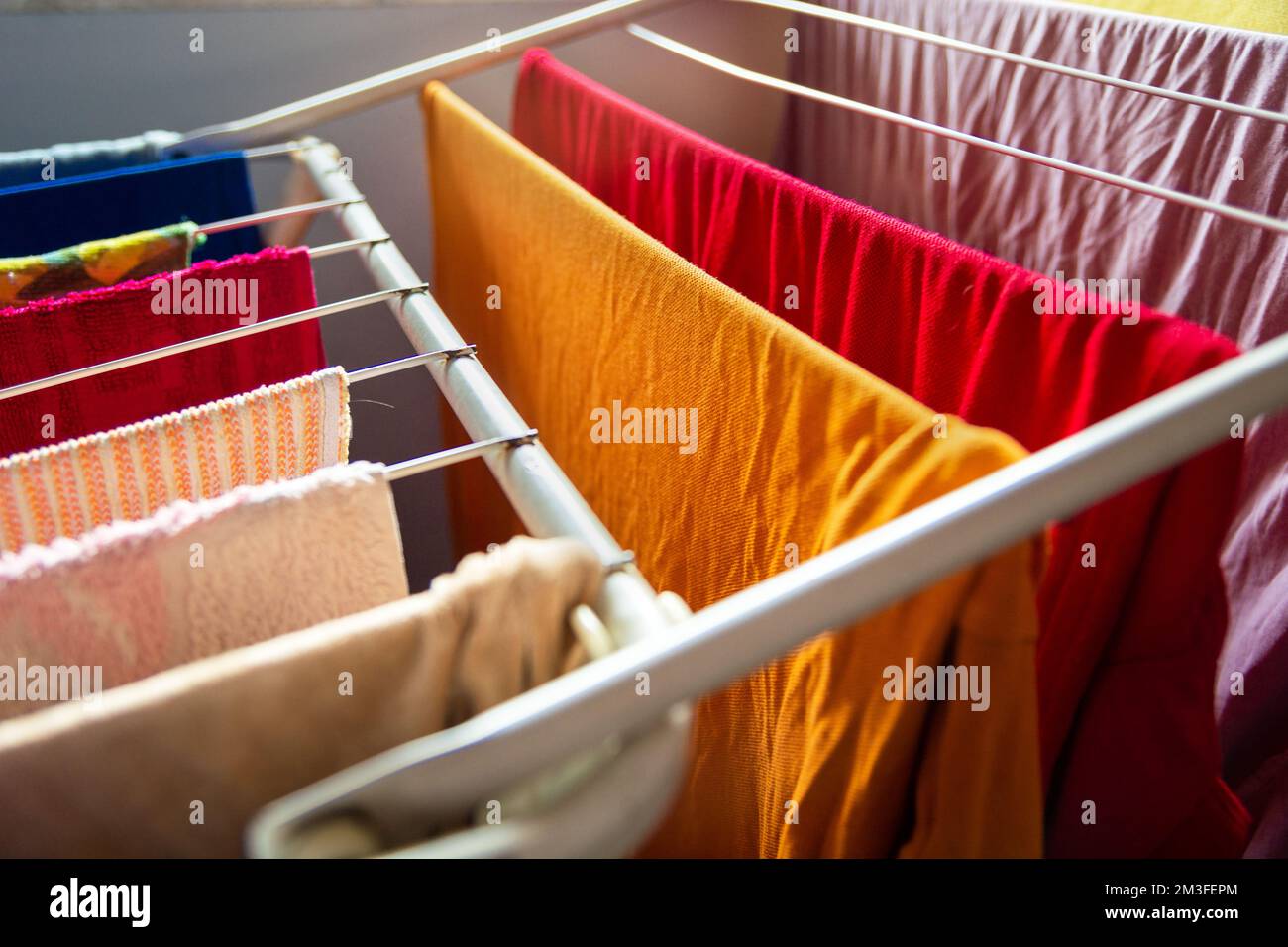 Close-up of washed colorful clothes hanging on the dryer Stock Photo