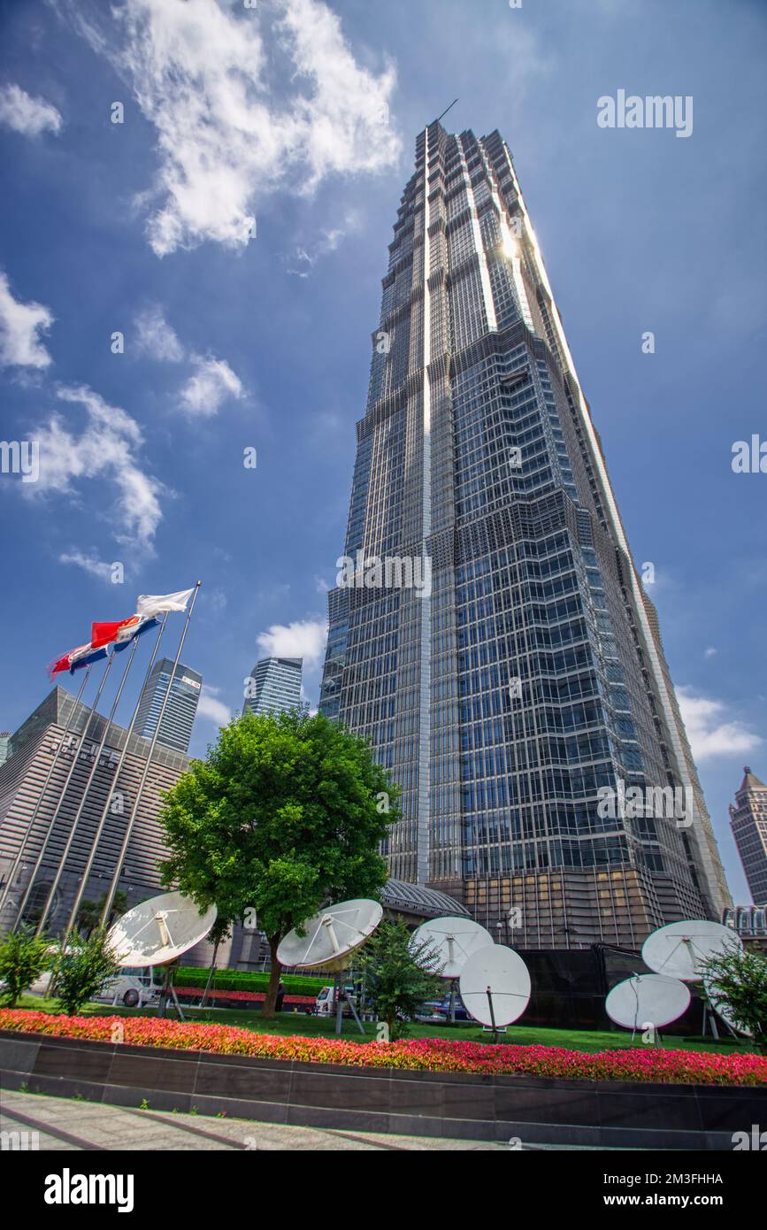 Jin Mao Tower, Shanghai, China photographed from below with a wide lens in summer against a blue sky and clouds Stock Photo