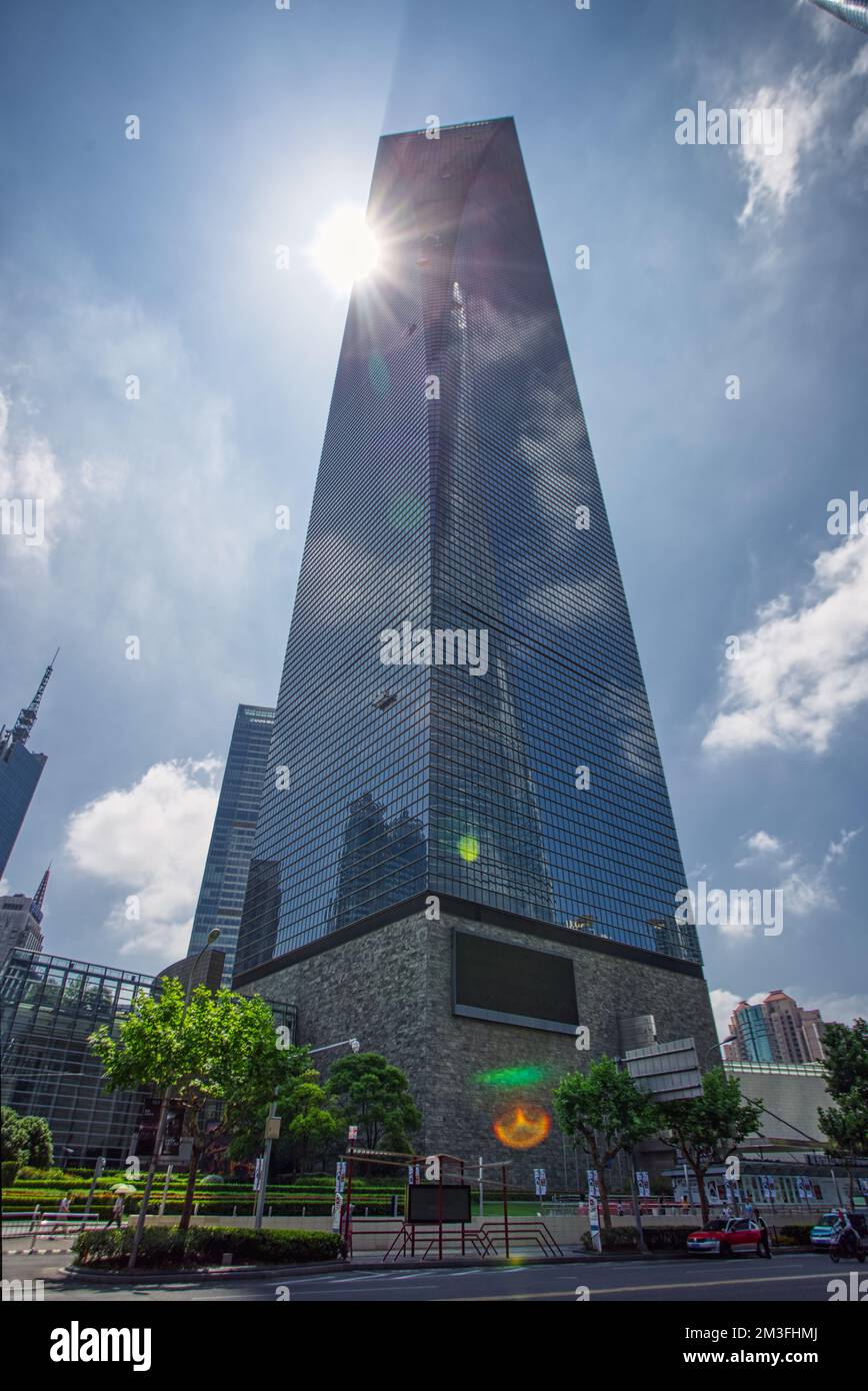 Shanghai World Financial Center, Shanghai, China shot from below with a wide lens in summer against a bright shining sun, blue sky and clouds Stock Photo