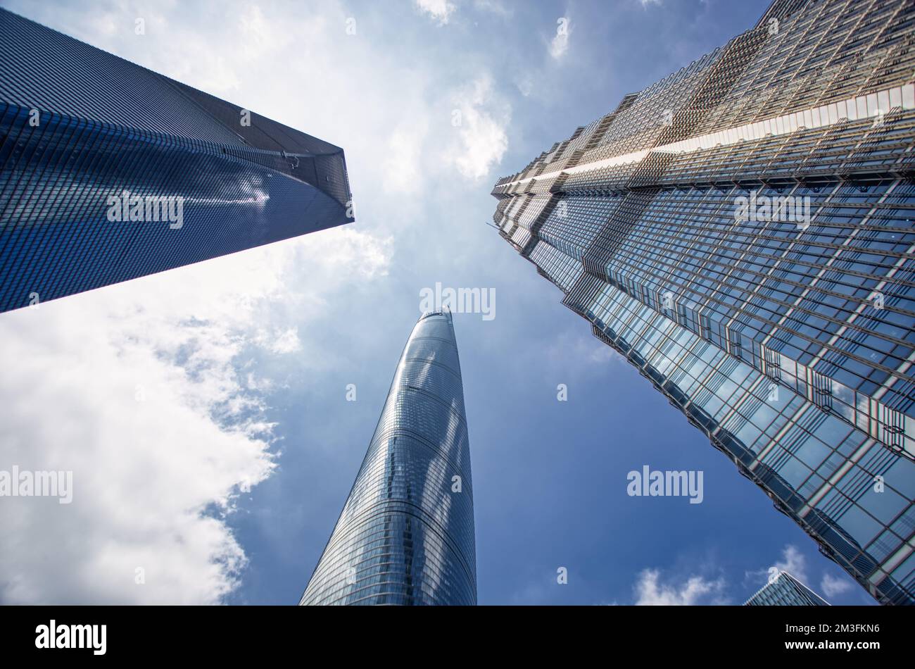 Shanghai World Financial Center,Shanghai tower and Jin Mao Tower photographed from below with a wide lens in summer against a blue sky and clouds Stock Photo