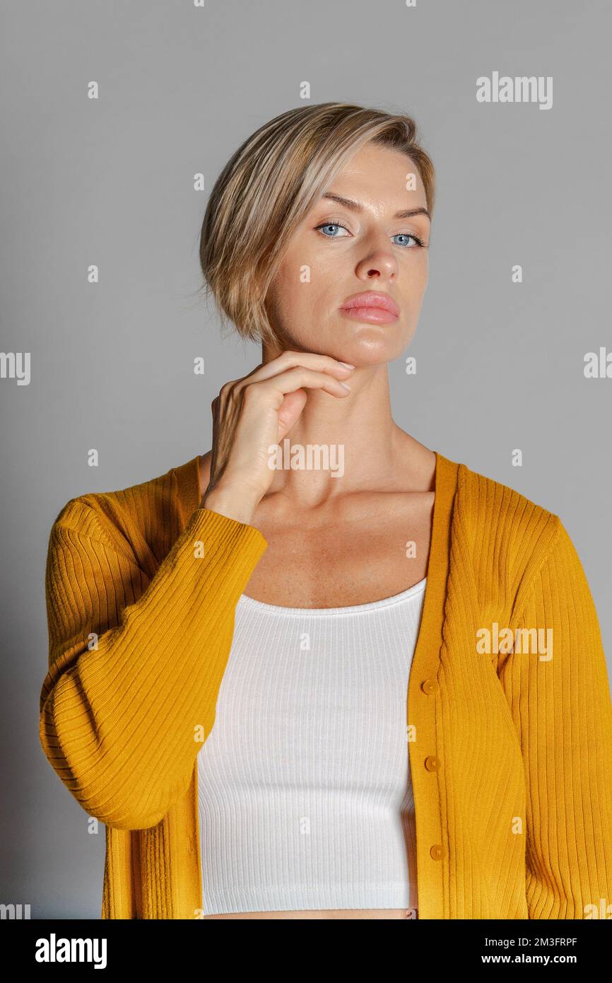 Portrait beautiful woman of model appearance. Girl in yellow jumper. Studio photography. High