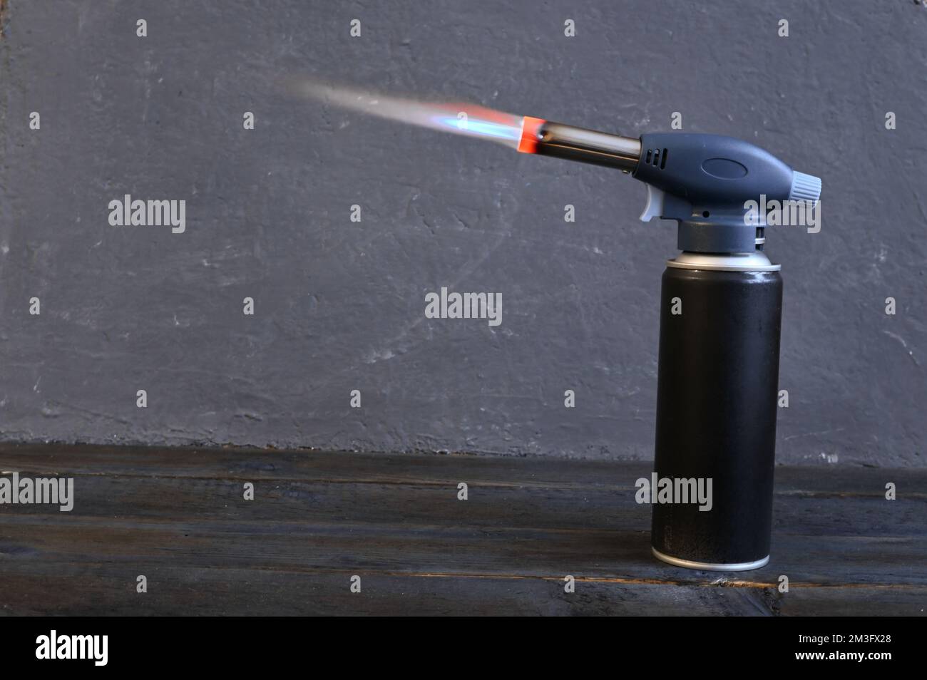 fire from the nozzle of a gas soldering iron put on a tourist gas cylinder. High quality photo Stock Photo
