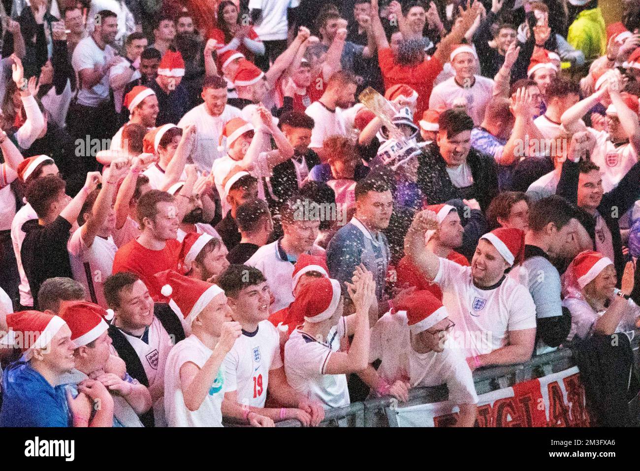 England fans throw beer in the air at Boxpark, Wembley, London, as England team scores goal against Senegal in tonight’s World Cup match.  Image shot Stock Photo