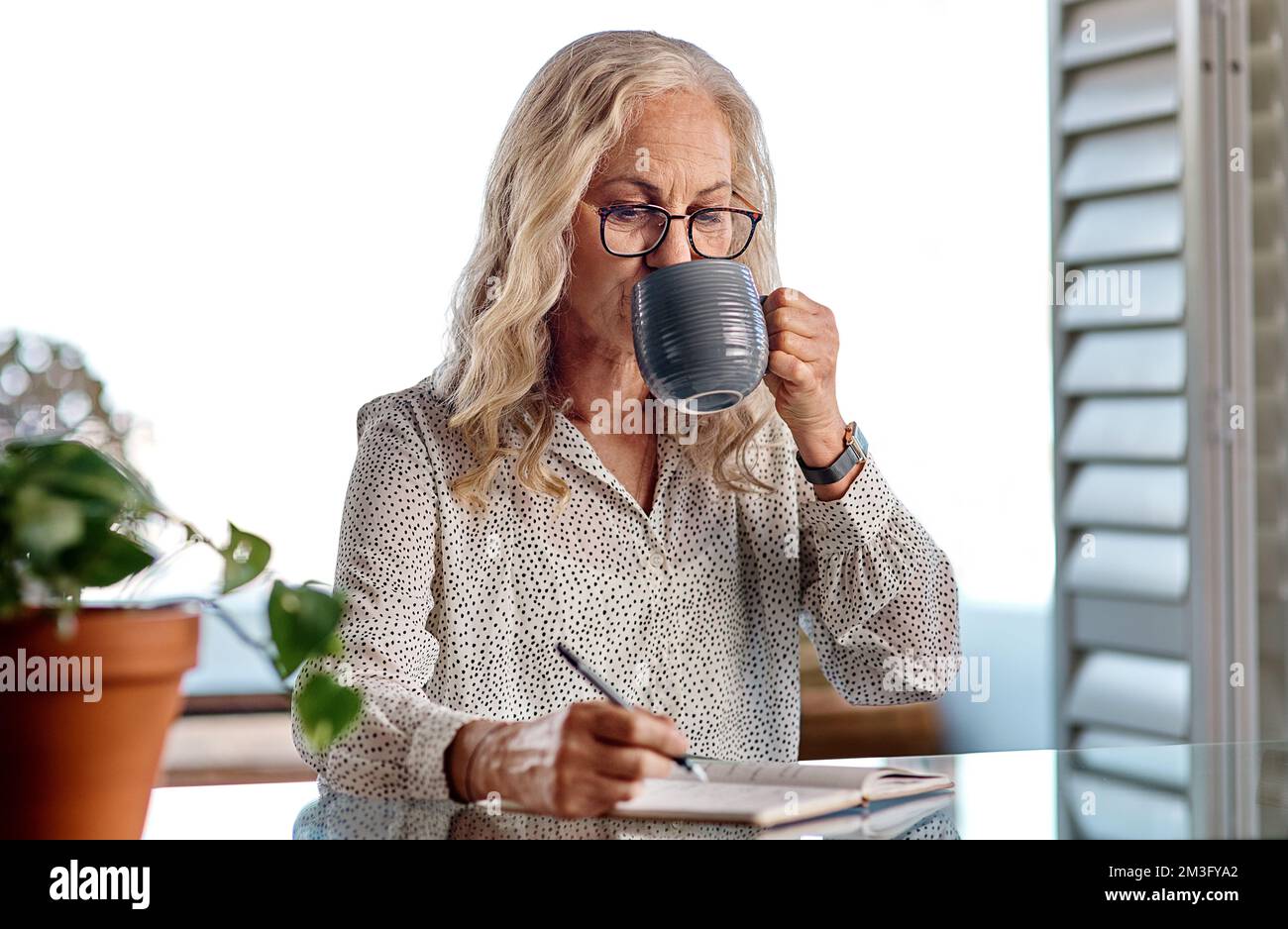 View of Strong coffee will keep you going. an attractive senior businesswoman ...