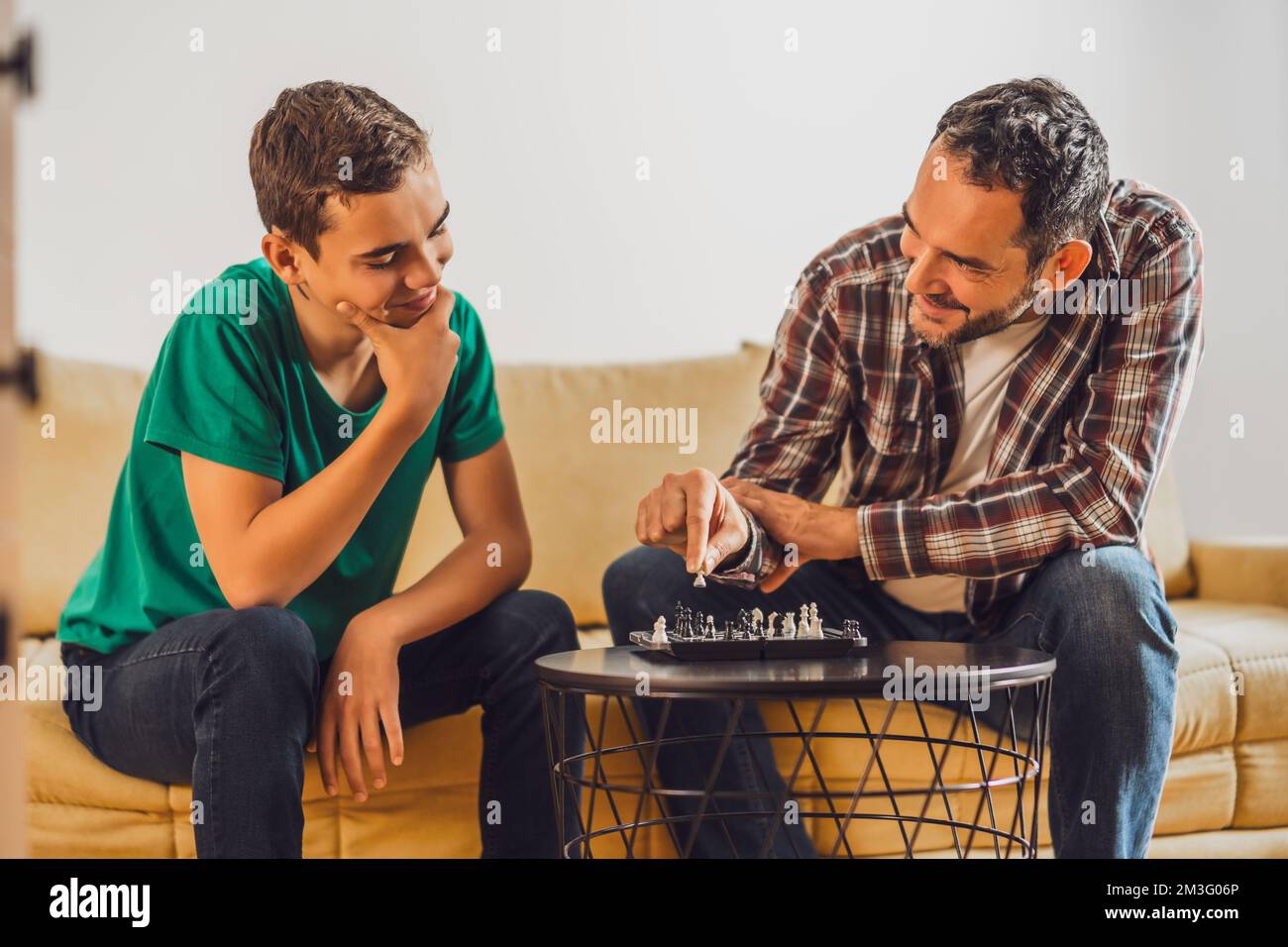 Father and son are playing chess at home. Stock Photo