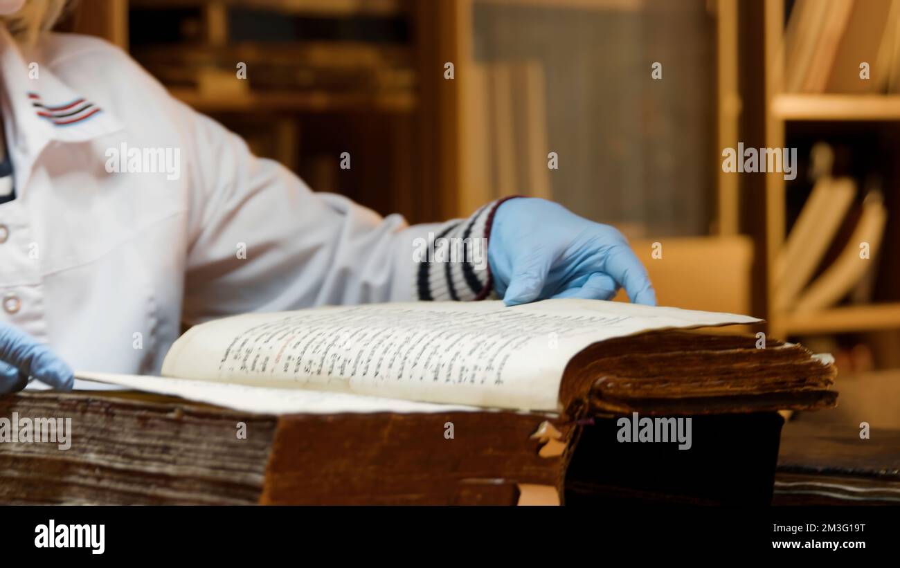 The master is restoring an old book. Stock footage. Close up of a book