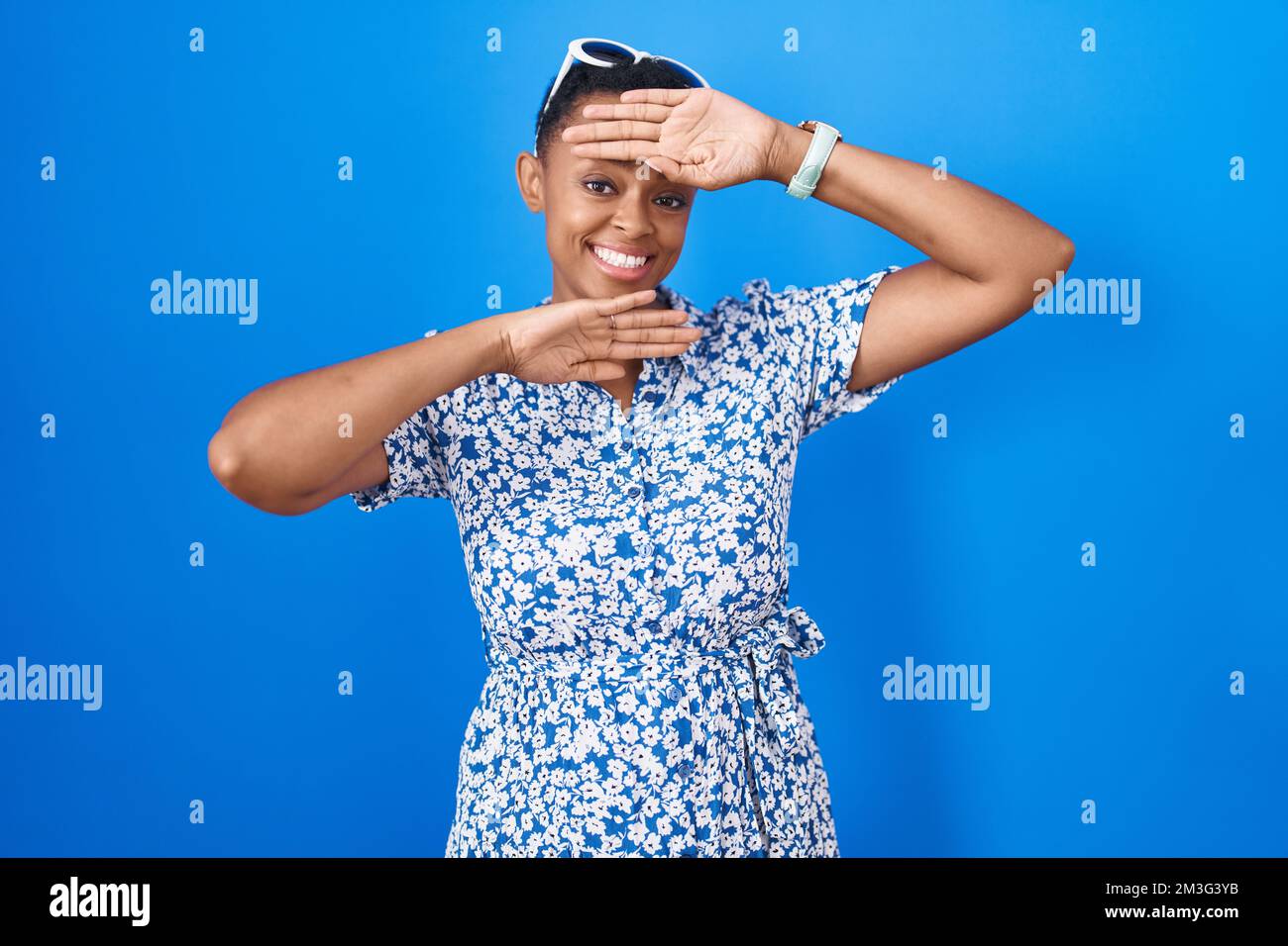 African american woman standing over blue background smiling cheerful ...