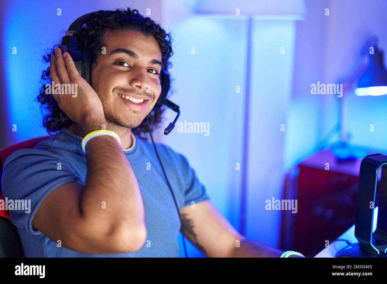 Young latin man streamer smiling confident sitting on table at gaming ...