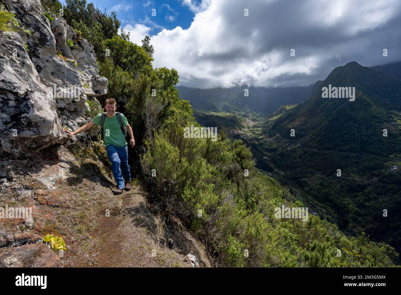 Hikers at Pico do Alto, panorama, view of densely overgrown cloud-covered mountains and the village of Boaventura, Madeira, Portugal Stock Photo