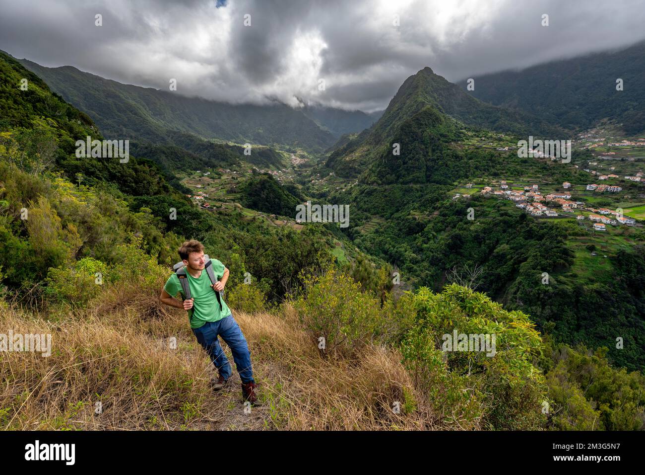 Hikers at Pico do Alto, panorama, view of densely overgrown cloud-covered mountains and the village of Boaventura, Madeira, Portugal Stock Photo
