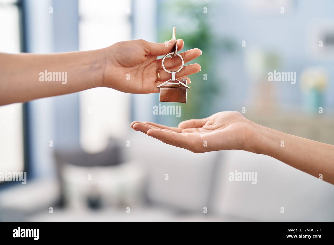 Young woman holding key of new house at home Stock Photo - Alamy