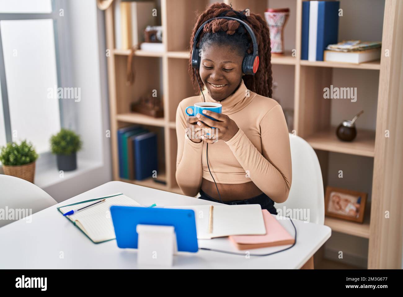 African american woman student listening to music drinking coffee at ...