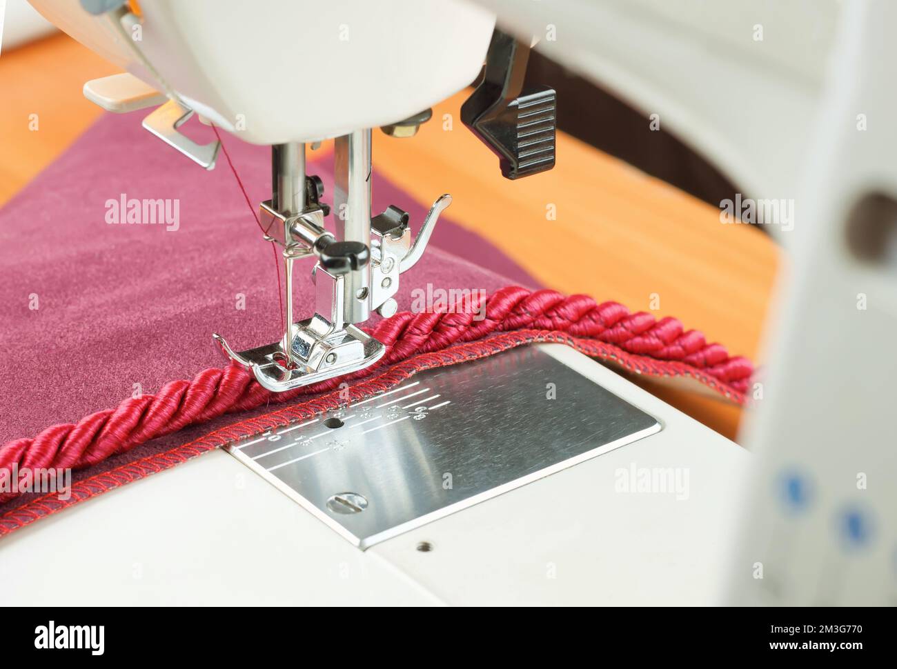 sewing machine needle and decorative edging cord. seiwng process Stock