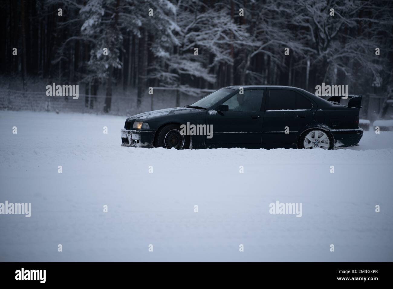 12-12-2022 Riga, Latvia  a car is parked in the snow near a forest of trees and snow covered ground with a few inches of snow on the ground. . Stock Photo