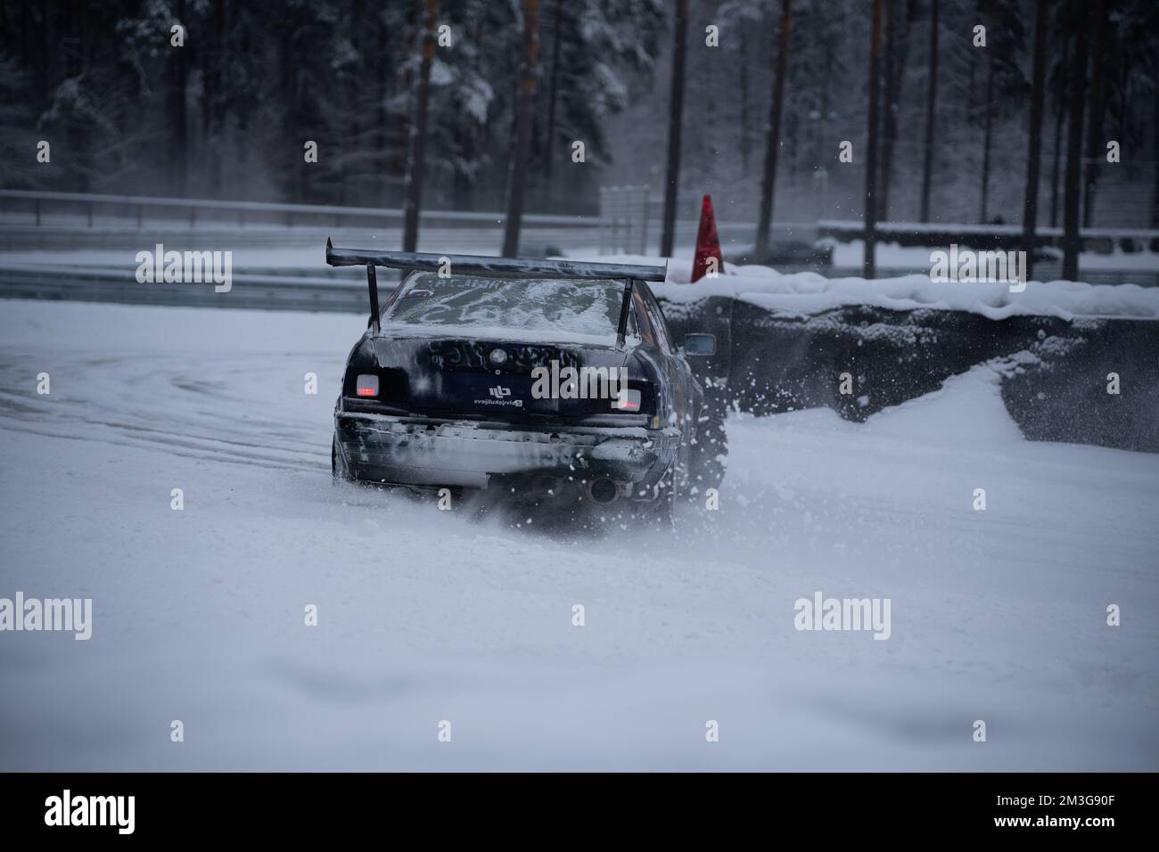 12-12-2022 Riga, Latvia  a car driving through a snow covered road in the middle of winter with a snow bank on the back of it. . Stock Photo