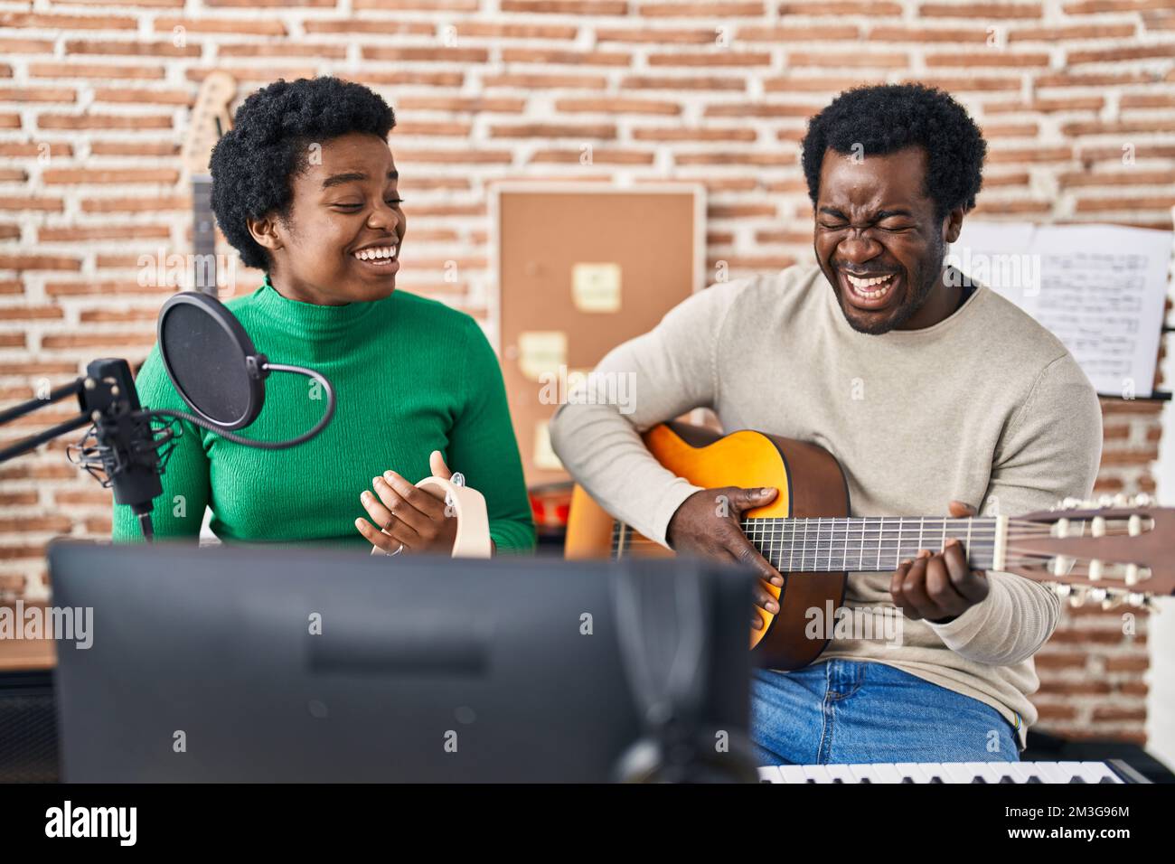African american man and woman music group singing song playing guitar and  tambourine at music studio Stock Photo - Alamy