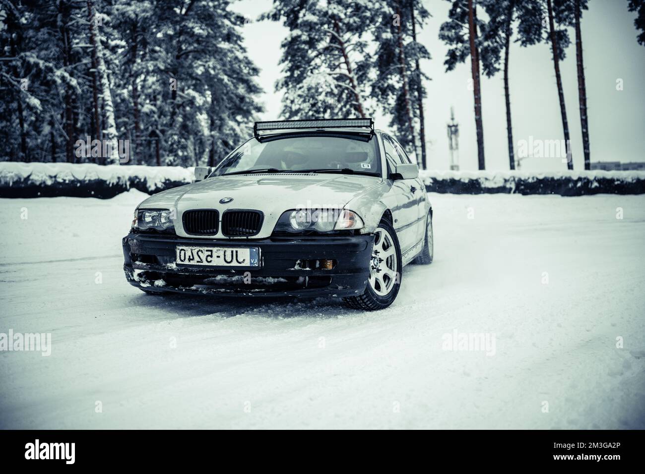 12-12-2022 Riga, Latvia  a car parked on a snowy road in the snow with trees in the background and snow on the ground. . Stock Photo